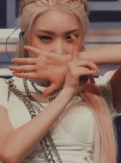 A Woman With Blonde Hair Is Covering Her Face With Her Hand GIF
