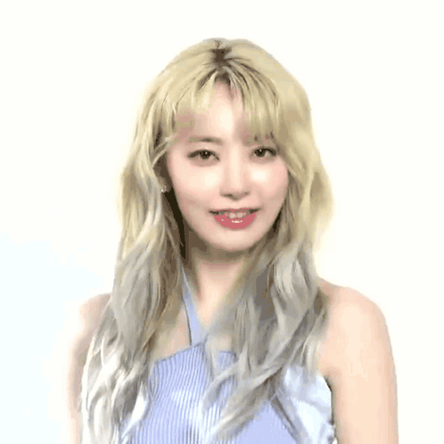 A Woman With Blonde Hair Is Covering Her Nose In Front Of A White Background With Korean Writing GIF