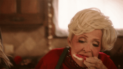 A Woman With Blonde Hair Is Eating A Piece Of Food GIF