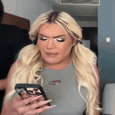A Woman With Blonde Hair Is Holding A Cell Phone With A Case That Says Nike On It GIF