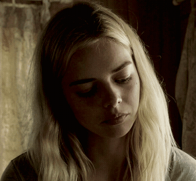 A Woman With Blonde Hair Is Looking Down At Something GIF
