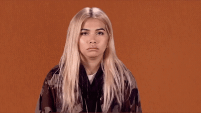 A Woman With Blonde Hair Is Making A Funny Face . GIF