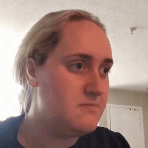 A Woman With Blonde Hair Is Making A Funny Face While Looking At The Camera . GIF