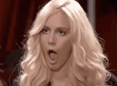 A Woman With Blonde Hair Is Making A Funny Face With Her Mouth Open . GIF