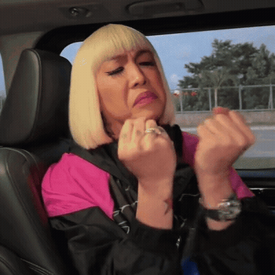 A Woman With Blonde Hair Is Sitting In The Back Seat Of A Car Making A Face GIF