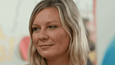 A Woman With Blonde Hair Is Smiling For The Camera GIF