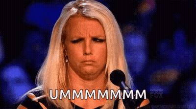 A Woman With Blonde Hair Is Standing In Front Of A Microphone And Says Ummmmmm GIF