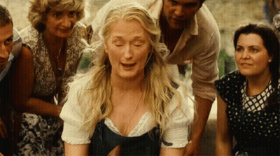 A Woman With Blonde Hair Is Surrounded By A Group Of People GIF