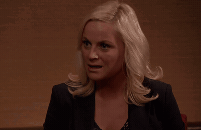 A Woman With Blonde Hair Is Wearing A Black Jacket And A Black Top GIF