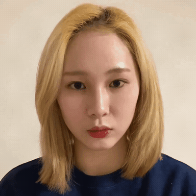 A Woman With Blonde Hair Is Wearing A Blue Sweater GIF