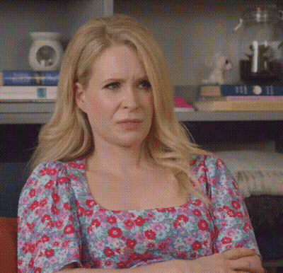 A Woman With Blonde Hair Is Wearing A Floral Dress GIF