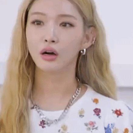 A Woman With Blonde Hair Is Wearing A Necklace And Earrings . GIF