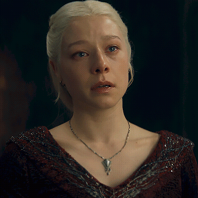 A Woman With Blonde Hair Is Wearing A Necklace With A Pendant GIF