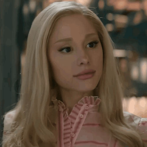 A Woman With Blonde Hair Is Wearing A Pink Shirt With Buttons GIF