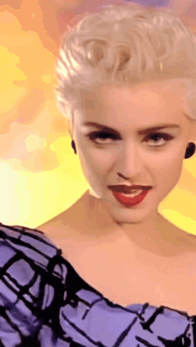 A Woman With Blonde Hair Is Wearing A Purple Dress GIF
