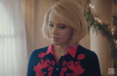 A Woman With Blonde Hair Is Wearing A Red And Blue Sweater And A Red Shirt . GIF