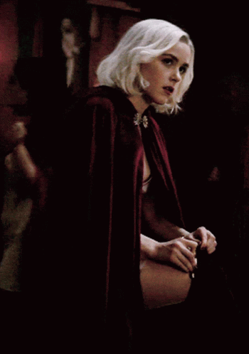 A Woman With Blonde Hair Is Wearing A Red Cape With A Hood GIF