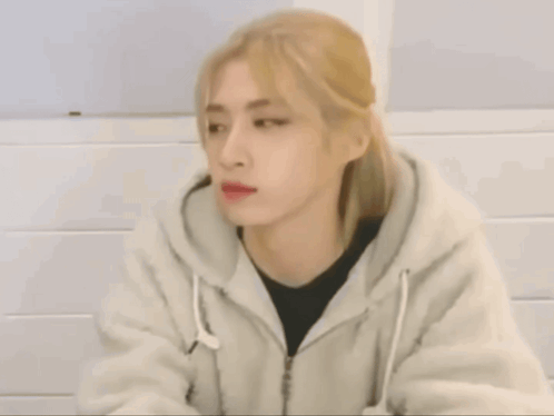 A Woman With Blonde Hair Is Wearing A White Jacket GIF