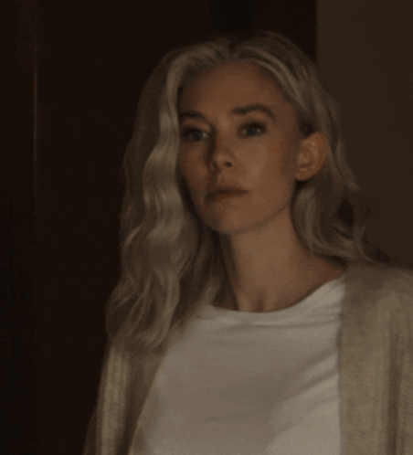A Woman With Blonde Hair Is Wearing A White Shirt GIF