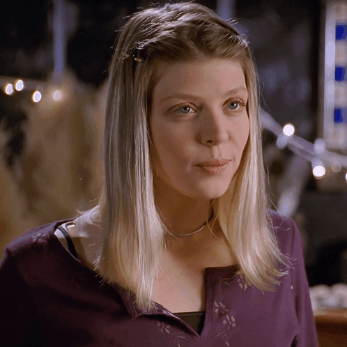 A Woman With Blonde Hair Wearing A Purple Sweater GIF