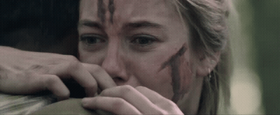 A Woman With Blood On Her Face Is Holding A Man 'S Arm GIF