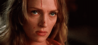 A Woman With Blood On Her Face Is Looking At The Camera . GIF