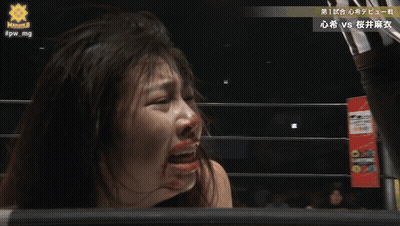 A Woman With Blood On Her Face Is Standing In A Wrestling Ring With The Hashtag #Pw_mg On The Bottom GIF