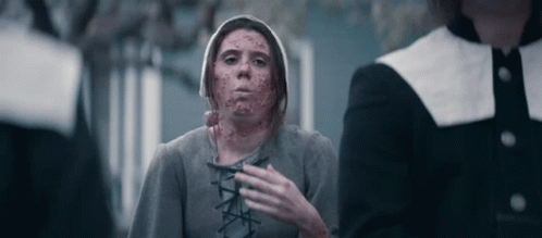 A Woman With Blood On Her Face Is Standing Next To A Man In A Black Jacket . GIF
