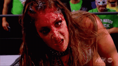 A Woman With Blood On Her Face Is Wearing A Shirt That Says Tnt On It GIF
