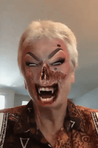 A Woman With Blood On Her Face Is Wearing A Shirt With The Letter V On The Sleeve GIF