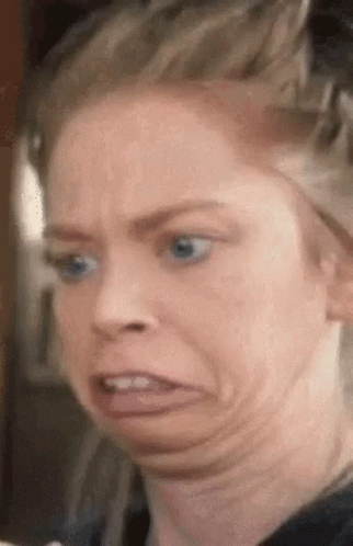 A Woman With Blue Eyes Is Making A Funny Face With Her Tongue Out . GIF
