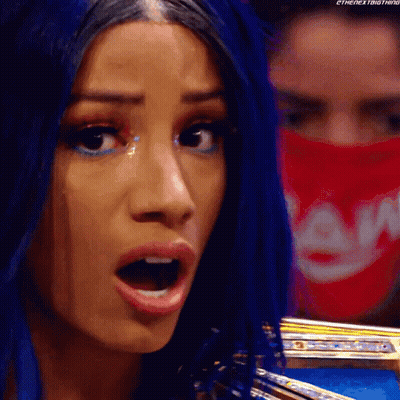 A Woman With Blue Hair And A Red Bandana On Her Face Is Making A Funny Face . GIF