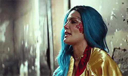 A Woman With Blue Hair And A Tattoo On Her Face . GIF
