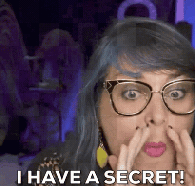 A Woman With Blue Hair And Glasses Is Saying I Have A Secret GIF