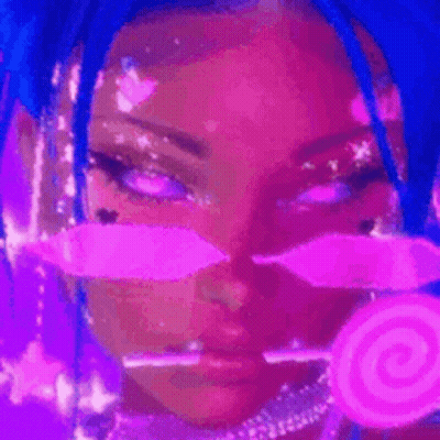A Woman With Blue Hair And Pink Makeup Is Holding A Pink Lollipop In Her Hand . GIF