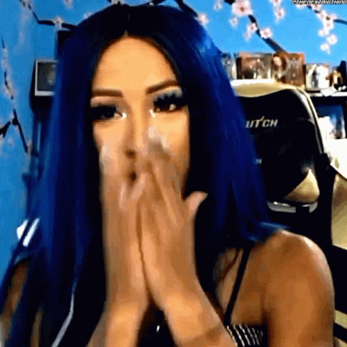 A Woman With Blue Hair Covering Her Mouth With Her Hands GIF