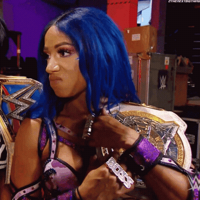 A Woman With Blue Hair Is Holding A Wrestling Championship GIF