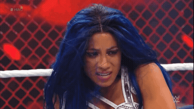 A Woman With Blue Hair Is In A Wrestling Ring With The Hashtag #Hug On The Screen GIF