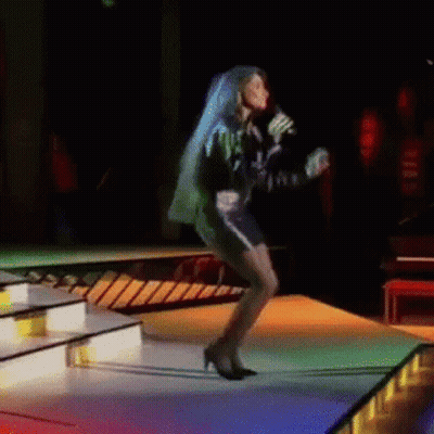 A Woman With Blue Hair Is Singing Into A Microphone GIF