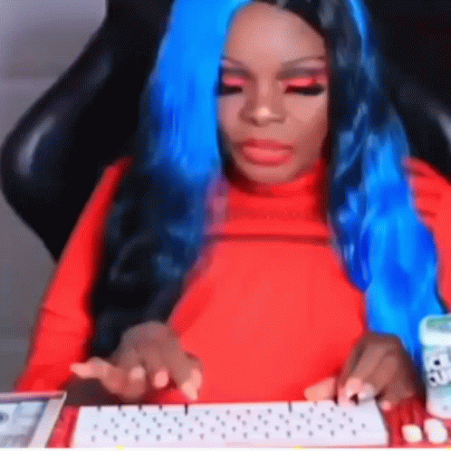 A Woman With Blue Hair Is Sitting At A Keyboard GIF