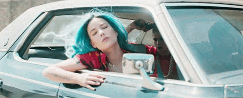 A Woman With Blue Hair Is Sitting In A Blue Car GIF