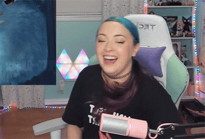 A Woman With Blue Hair Is Sitting In A Chair With The Word Det On The Back GIF
