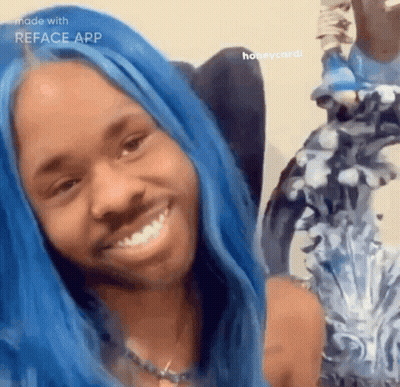 A Woman With Blue Hair Is Smiling In Front Of A Mirror GIF