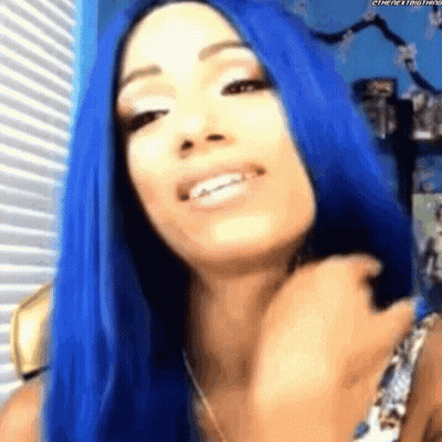 A Woman With Blue Hair Is Smiling While Looking At The Camera . GIF