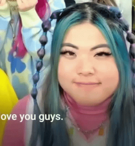 A Woman With Blue Hair Is Smiling With The Words " Love You Guys " In The Corner GIF