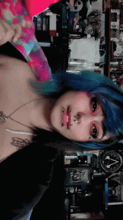 A Woman With Blue Hair Is Standing In Front Of A Sign That Says ' Apocalypse ' GIF
