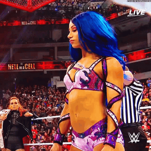 A Woman With Blue Hair Is Standing In Front Of A Sign That Says " Hell In A Cell " GIF