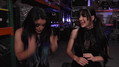 A Woman With Blue Hair Is Talking To Another Woman GIF