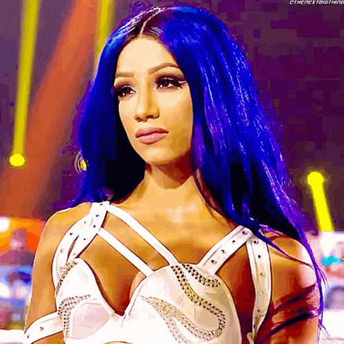 A Woman With Blue Hair Is Wearing A White Top With Studs GIF