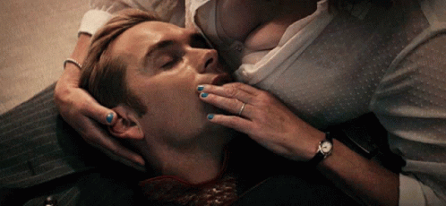 A Woman With Blue Nail Polish Is Kissing A Man On The Neck GIF